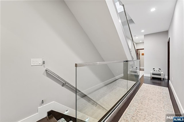 stairway featuring recessed lighting, wood finished floors, and baseboards