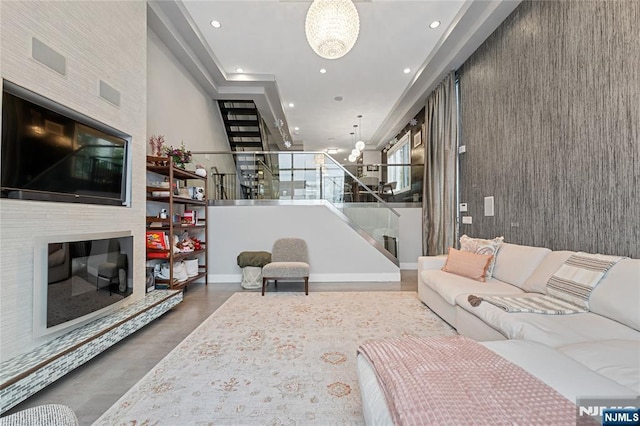 living area featuring stairway, recessed lighting, a fireplace, wood finished floors, and a notable chandelier