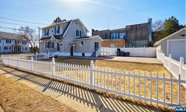 view of front of house with a fenced front yard and a gambrel roof