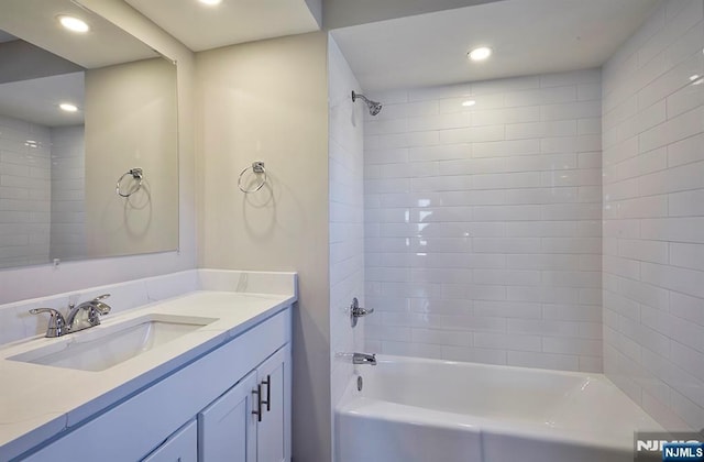 bathroom featuring vanity, recessed lighting, and washtub / shower combination