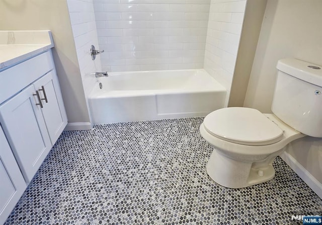 full bath with baseboards, toilet, vanity, and shower / tub combination