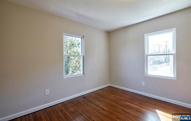 unfurnished room with baseboards and hardwood / wood-style flooring