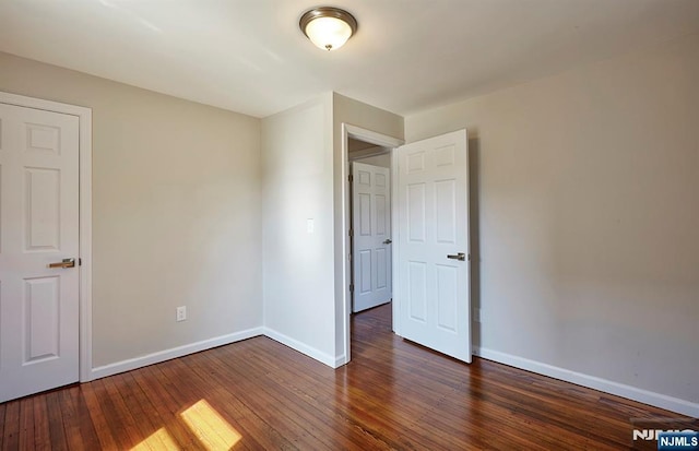 unfurnished bedroom with baseboards and hardwood / wood-style flooring