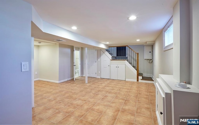 basement featuring visible vents, baseboards, stairway, electric panel, and recessed lighting