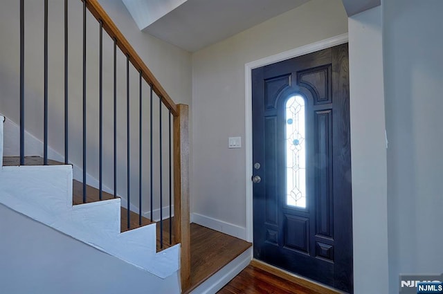 foyer with stairway, baseboards, and wood finished floors