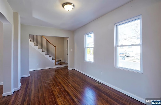 entryway featuring visible vents, baseboards, dark wood finished floors, and stairs