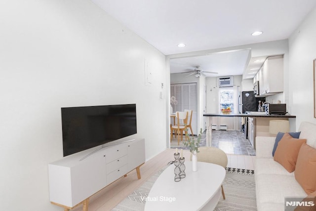 living area with recessed lighting, a ceiling fan, light wood-type flooring, and a baseboard radiator