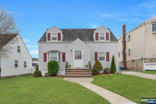 cape cod-style house featuring a front yard and a shingled roof