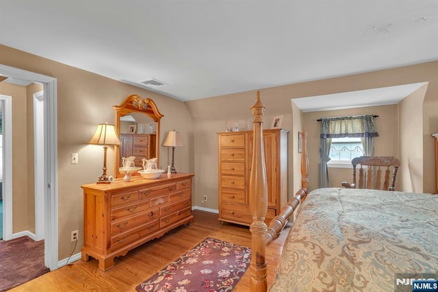 bedroom with wood finished floors, visible vents, and baseboards