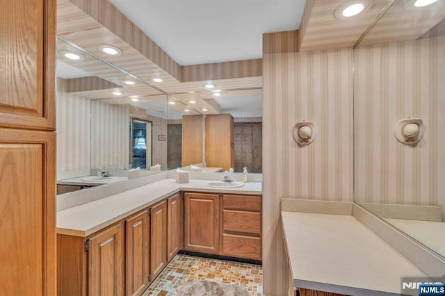 bathroom with wallpapered walls, recessed lighting, and vanity