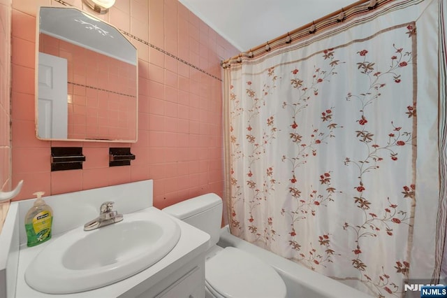 full bathroom featuring toilet, tile walls, vanity, and shower / bathtub combination with curtain