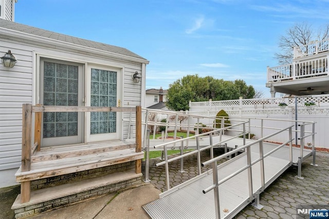 exterior space featuring a balcony and fence