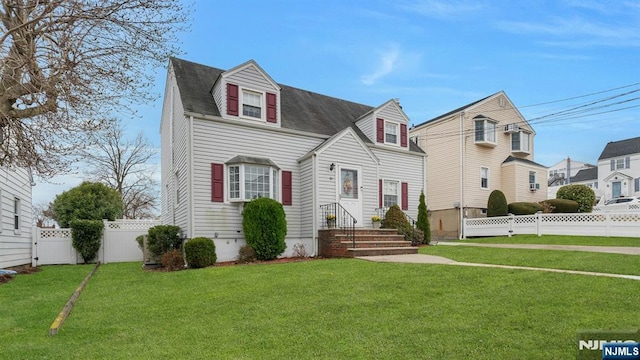 cape cod-style house featuring a front yard and a fenced backyard