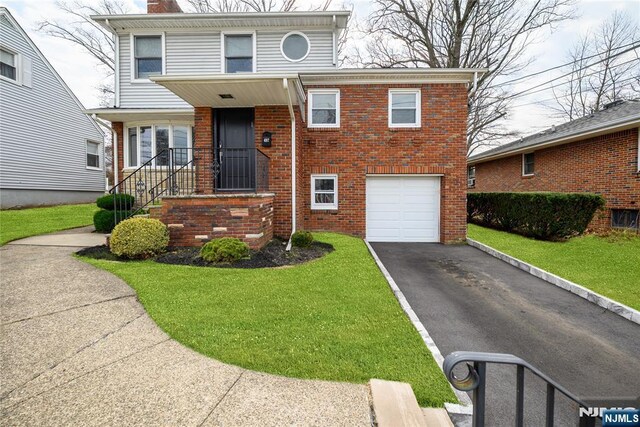 view of front facade featuring brick siding, driveway, an attached garage, and a front lawn