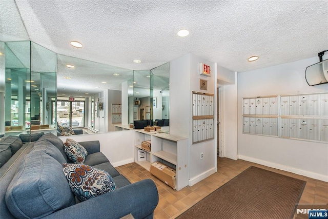 interior space featuring recessed lighting, mail area, baseboards, and a textured ceiling