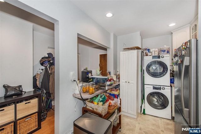 laundry area with recessed lighting, stacked washer and clothes dryer, and laundry area