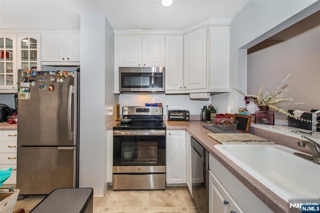 kitchen with a sink, stainless steel appliances, white cabinets, and light countertops