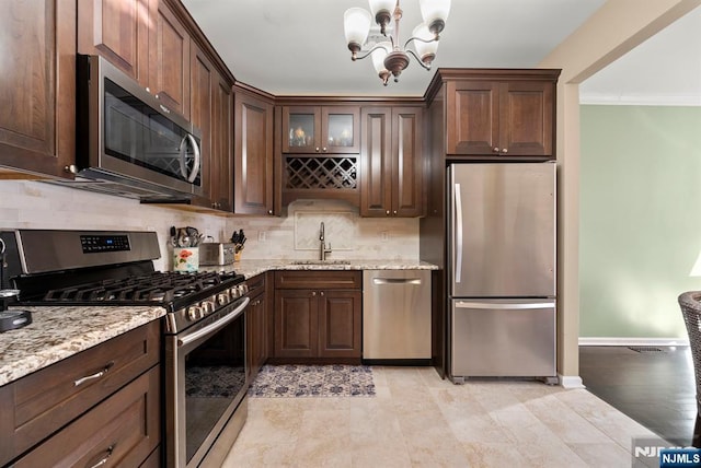 kitchen featuring a sink, tasteful backsplash, stainless steel appliances, dark brown cabinetry, and a chandelier