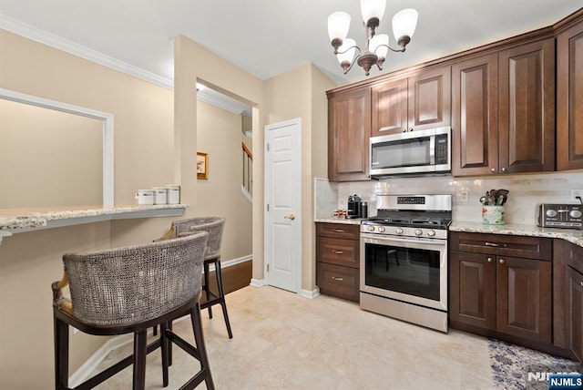 kitchen featuring ornamental molding, backsplash, stainless steel appliances, dark brown cabinets, and a chandelier