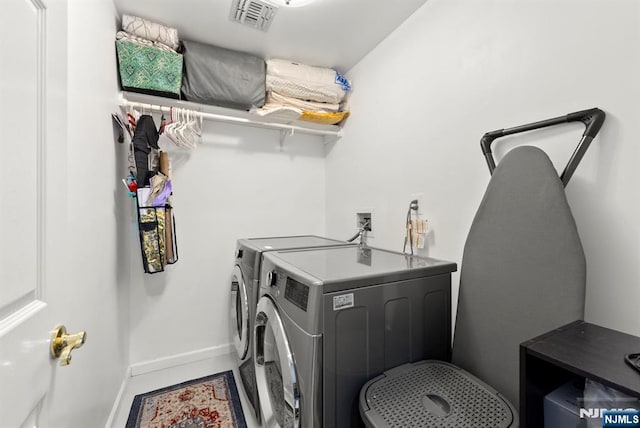 laundry area featuring washer and dryer, visible vents, baseboards, and laundry area