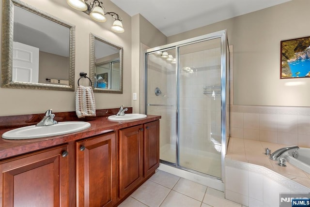 bathroom with tile patterned flooring, a shower stall, double vanity, and a sink