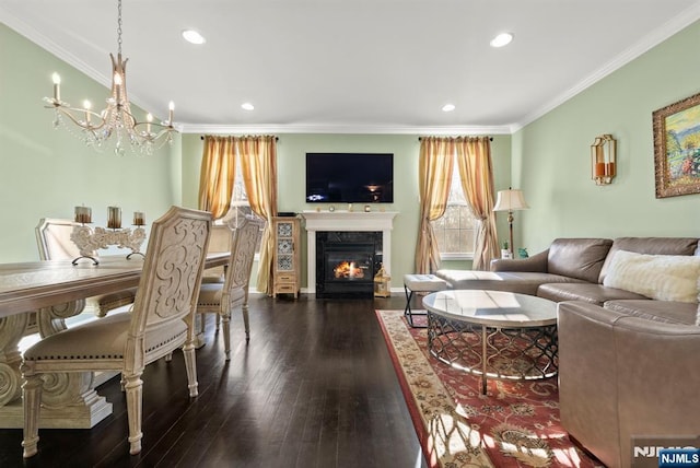 living room featuring a notable chandelier, a high end fireplace, recessed lighting, crown molding, and dark wood-style flooring