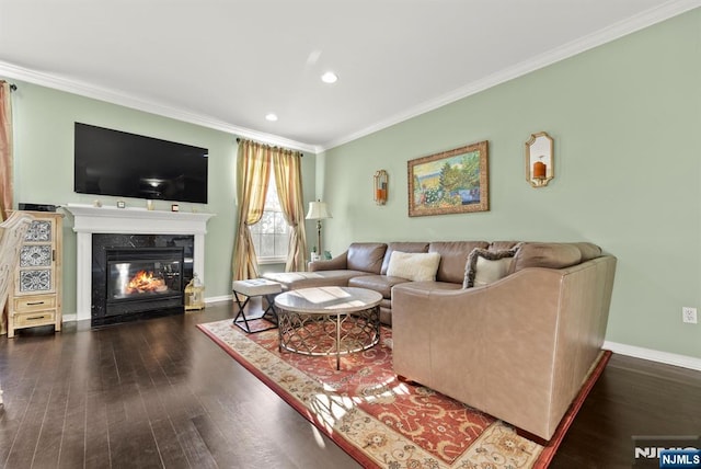 living room featuring dark wood finished floors, a premium fireplace, baseboards, and ornamental molding