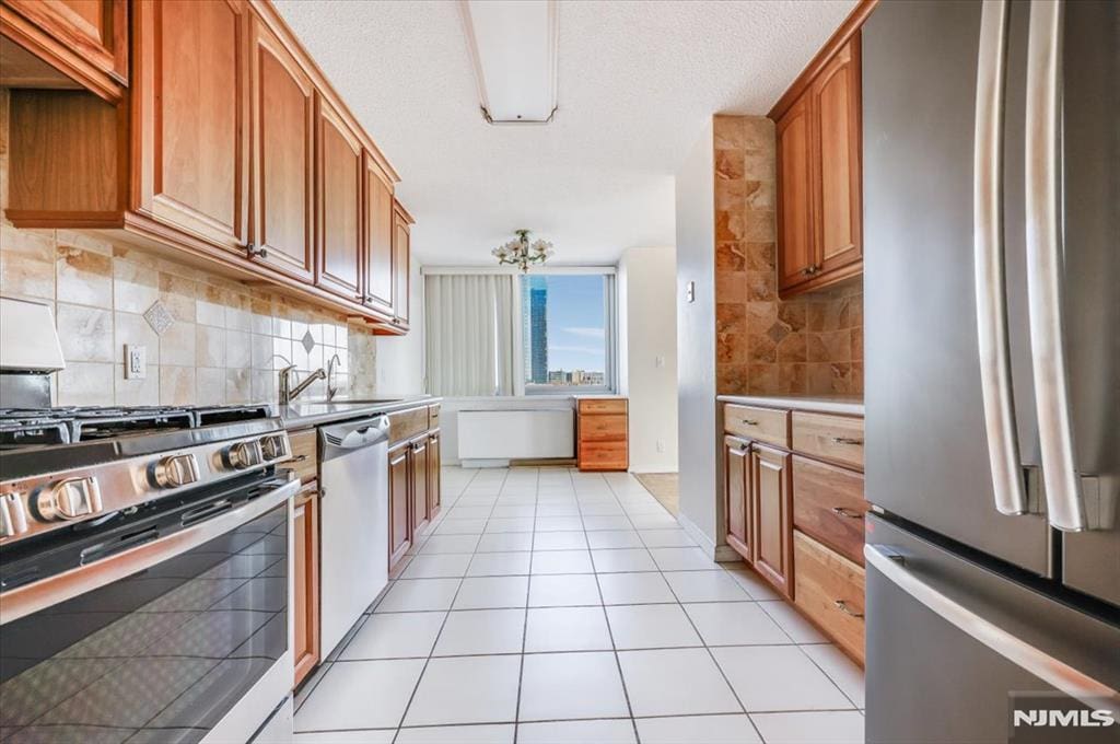 1600 Parker Ave Unit 7C, Fort Lee, NJ 07024 - kitchen with tasteful backsplash, light tile patterned floors, brown cabinets, appliances with stainless steel finishes, and a sink