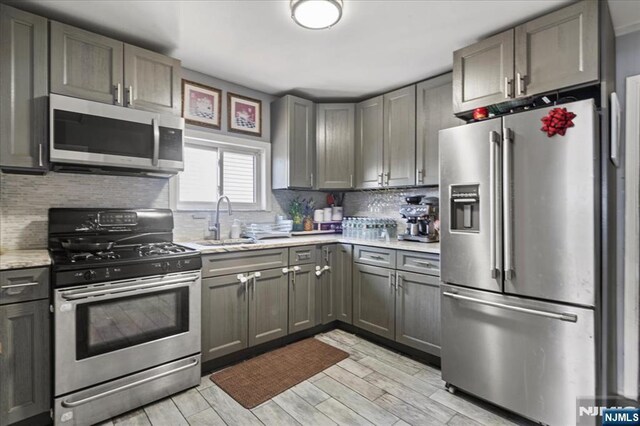 627 Montgomery, Elizabeth, NJ 07202 - kitchen featuring a sink, stainless steel appliances, wood finish floors, and tasteful backsplash