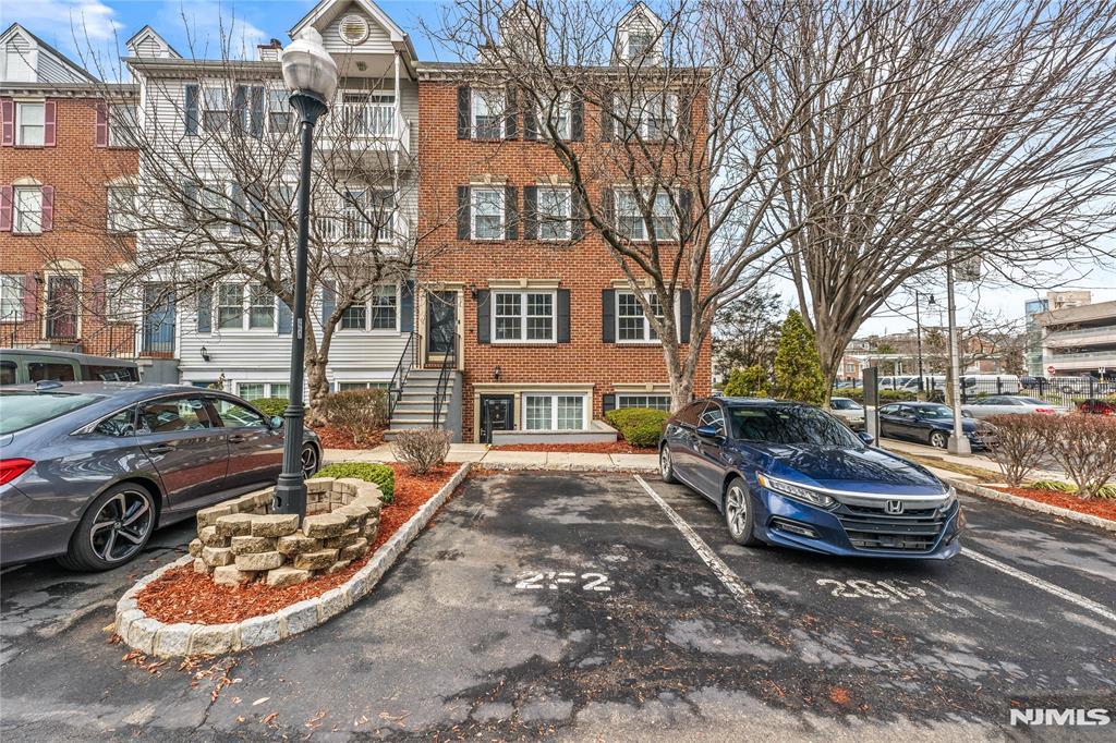 multi unit property with uncovered parking, brick siding, and a chimney
