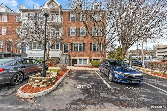 multi unit property with uncovered parking, brick siding, and a chimney