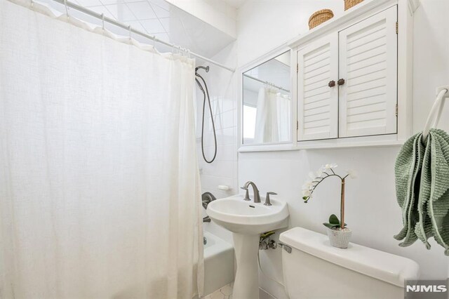 bathroom with shower / tub combo and toilet