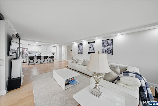 living area with recessed lighting and light wood finished floors
