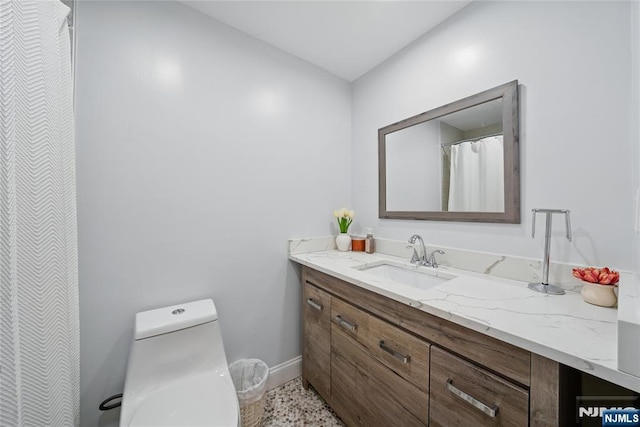 full bath featuring baseboards, toilet, and vanity
