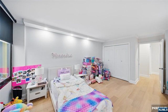 bedroom featuring light wood-style flooring, baseboards, and a closet