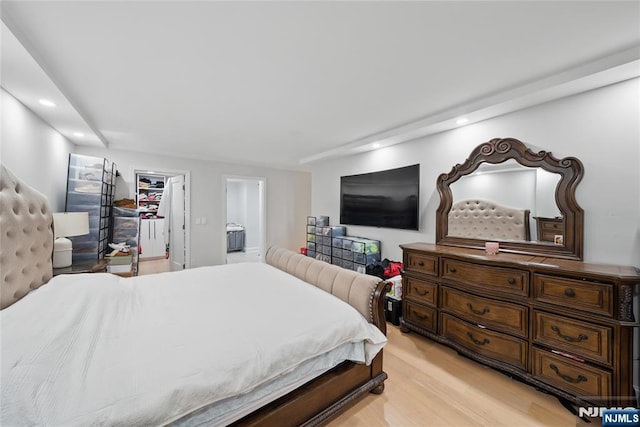 bedroom featuring light wood-style flooring, recessed lighting, a spacious closet, a closet, and connected bathroom
