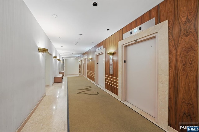 corridor with elevator and wooden walls