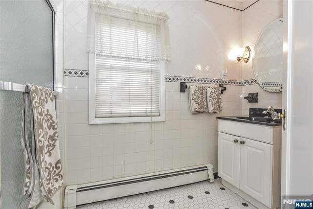 33 Bergen Ave, Waldwick, NJ 07463 - full bathroom featuring a baseboard heating unit, tile walls, vanity, and tile patterned flooring