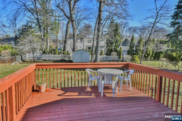 33 Bergen Ave, Waldwick, NJ 07463 - wooden terrace with an outbuilding, a lawn, outdoor dining space, a fenced backyard, and a storage shed