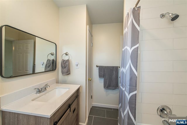 bathroom featuring tile patterned floors, vanity, shower / bath combo with shower curtain, and baseboards