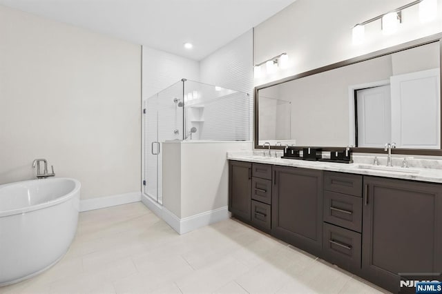 full bathroom with a stall shower, double vanity, a freestanding tub, and a sink