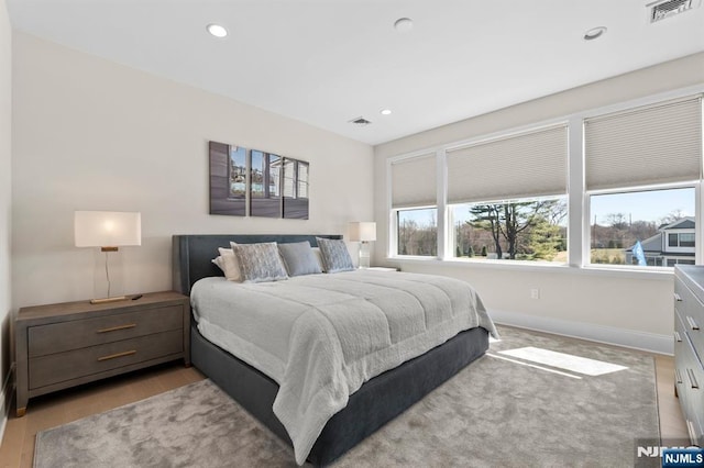bedroom with baseboards, visible vents, recessed lighting, and light wood finished floors