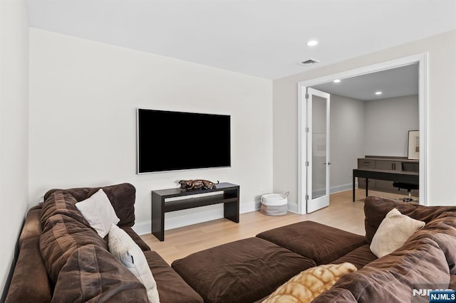 living area featuring baseboards, visible vents, and light wood-style floors
