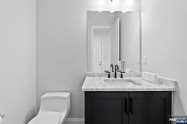 half bath featuring toilet and vanity