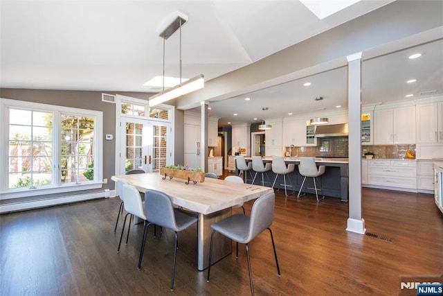 dining area featuring visible vents, baseboard heating, and dark wood-type flooring