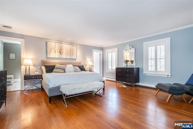 bedroom with crown molding, wood finished floors, and visible vents