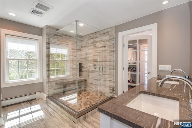 full bathroom featuring a shower stall, a baseboard heating unit, recessed lighting, and visible vents