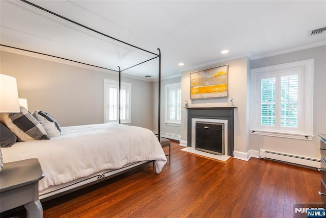 bedroom with visible vents, crown molding, dark wood finished floors, a baseboard radiator, and a baseboard heating unit