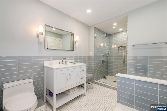 full bathroom with vanity, toilet, recessed lighting, tile walls, and a shower stall