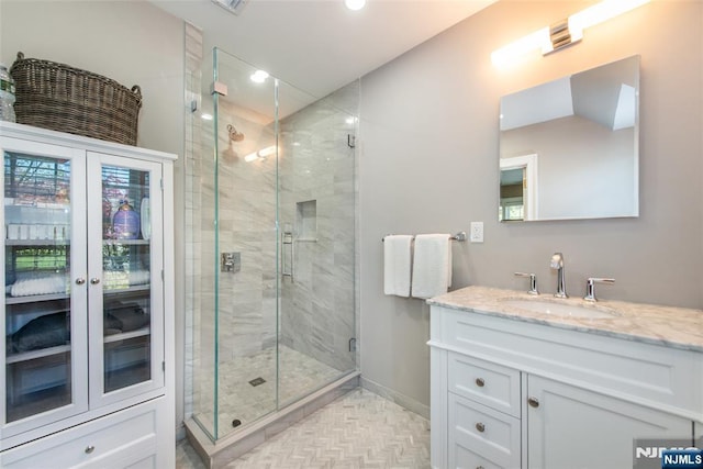 bathroom with recessed lighting, baseboards, a shower stall, and vanity